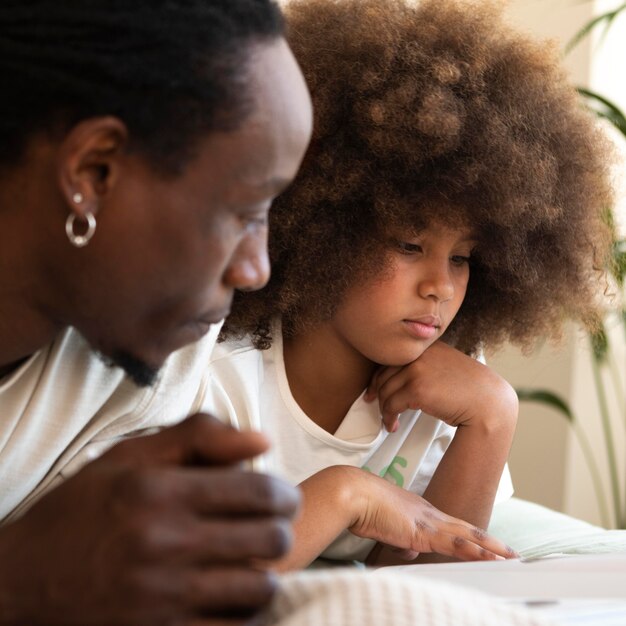 Hija y padre leyendo un libro juntos