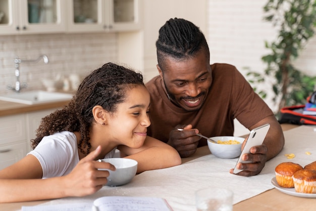 Hija y padre mirando un video por teléfono