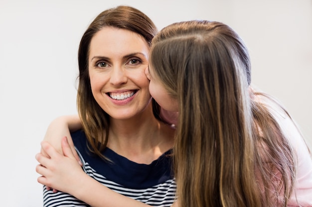 Foto gratuita hija que besa a su madre en la sala de estar