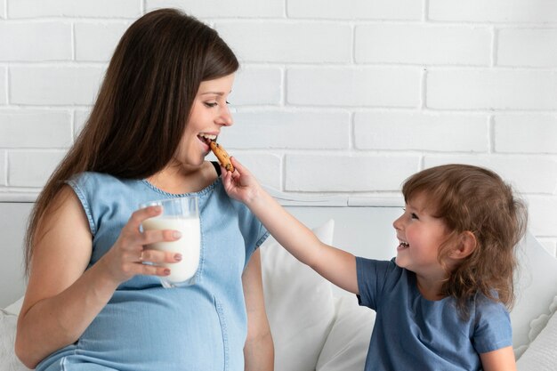 Hija que le da a su madre una galleta para comer