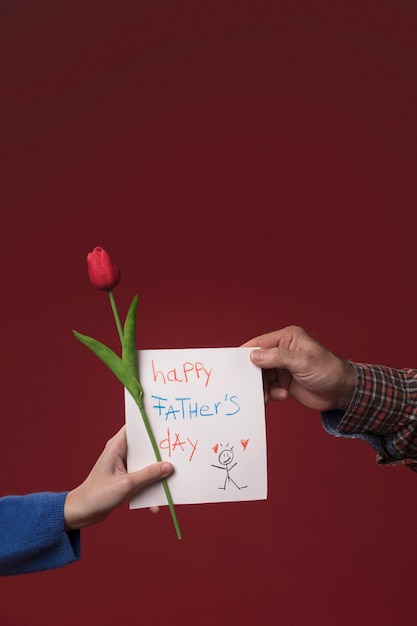 Hija que da la tarjeta de felicitación del día de padres del papá