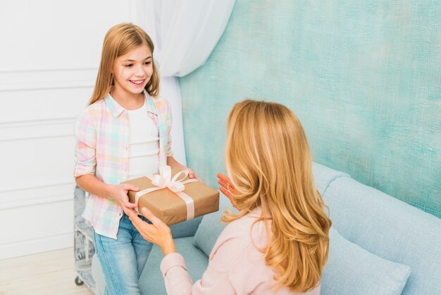 Hija regalando caja para madre.