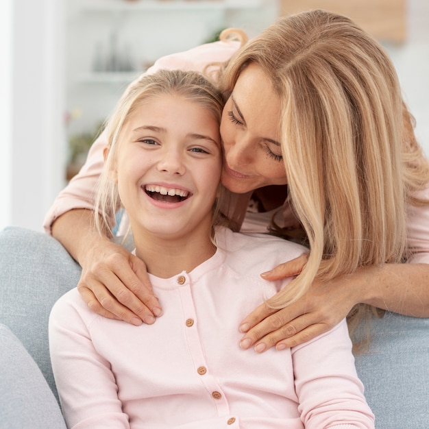 Hija sonriente besada por su madre