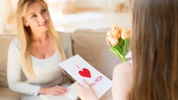 Hija sorprendente madre con flores.