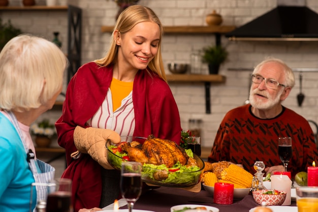 Hija trae el delicioso pavo a la mesa