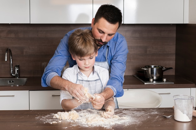 Foto gratuita hijo de ángulo bajo y masa rodante de papá