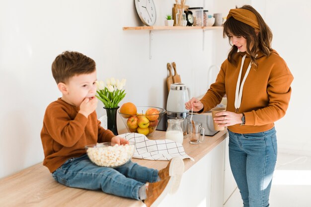 Hijo ayudando a mamá en la cocina