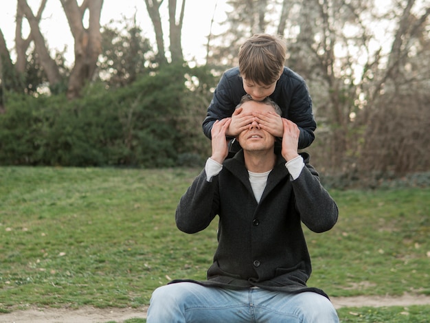 Foto gratuita hijo cubre los ojos de su padre