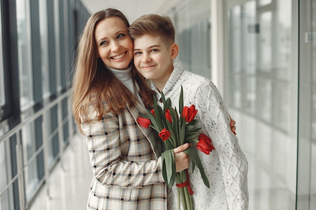 Foto gratuita hijo dando a una madre un ramo de tulipanes rojos en el salón amodern