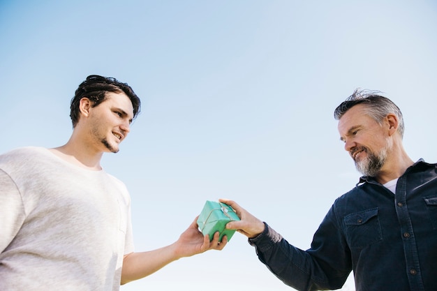 Foto gratuita hijo dando regalo a padre