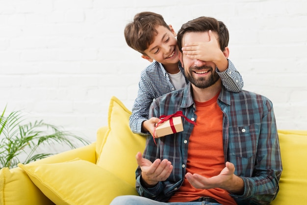 Hijo encantador haciendo una sorpresa a su padre