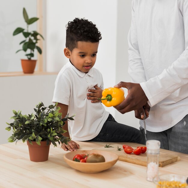 Hijo mirando a su padre preparando la cena