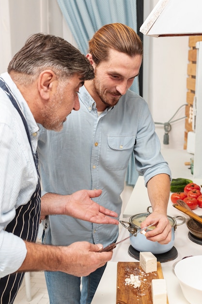 Hijo y padre confundido cocinando