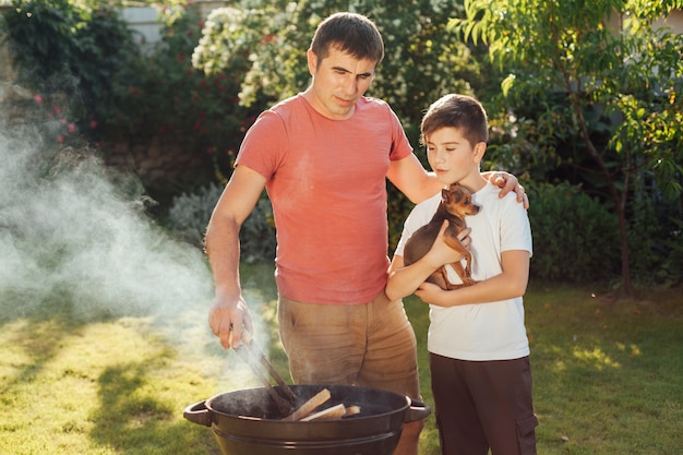 Foto gratuita hijo y padre preparando comida juntos en picnic