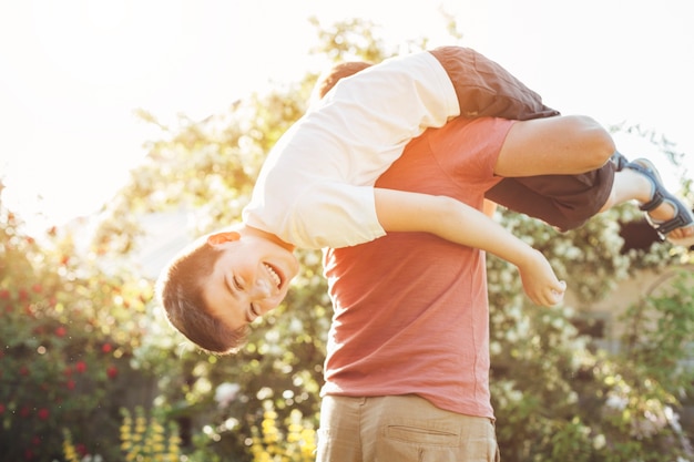 Hijo y padre sonrientes que se divierten en parque