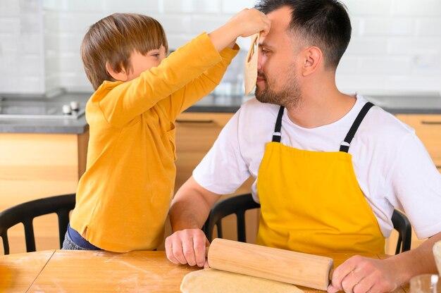 Hijo pone una máscara de masa en la cara de su padre