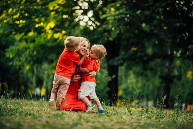 Hijos abrazando a su madre en el parque