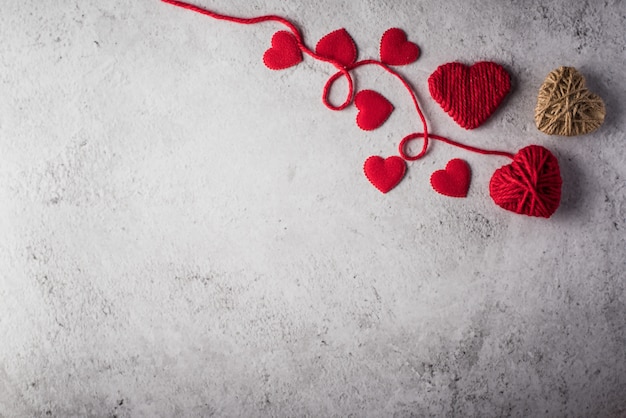 Hilado rojo en forma de corazón en el fondo de la pared