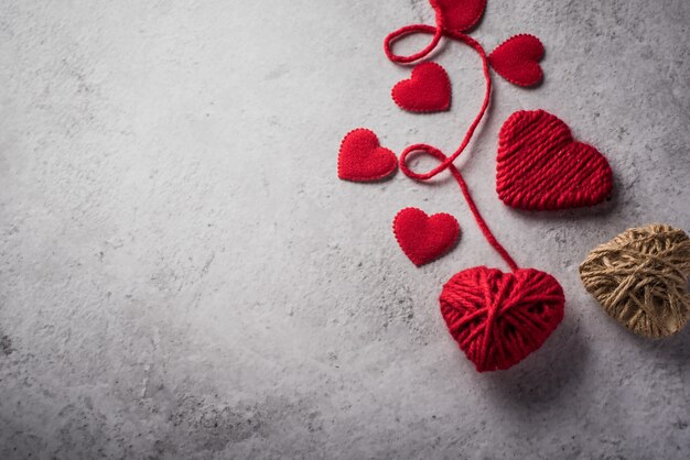 Hilado rojo en forma de corazón en el fondo de la pared