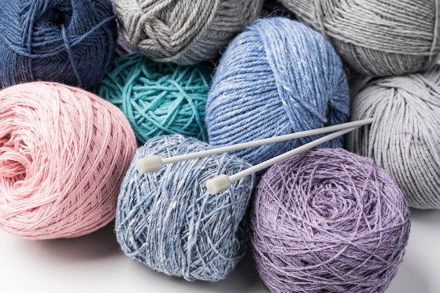 Hilados de lana de colores con agujas de plástico.