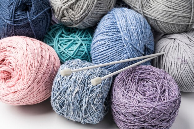 Hilados de lana de colores con agujas de plástico.