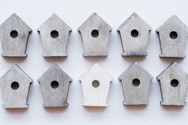 Foto gratuita hilera de casas de madera de aves sobre fondo blanco con textura