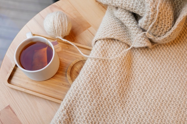 Foto gratuita hilo de tejer de alto ángulo y taza de té.