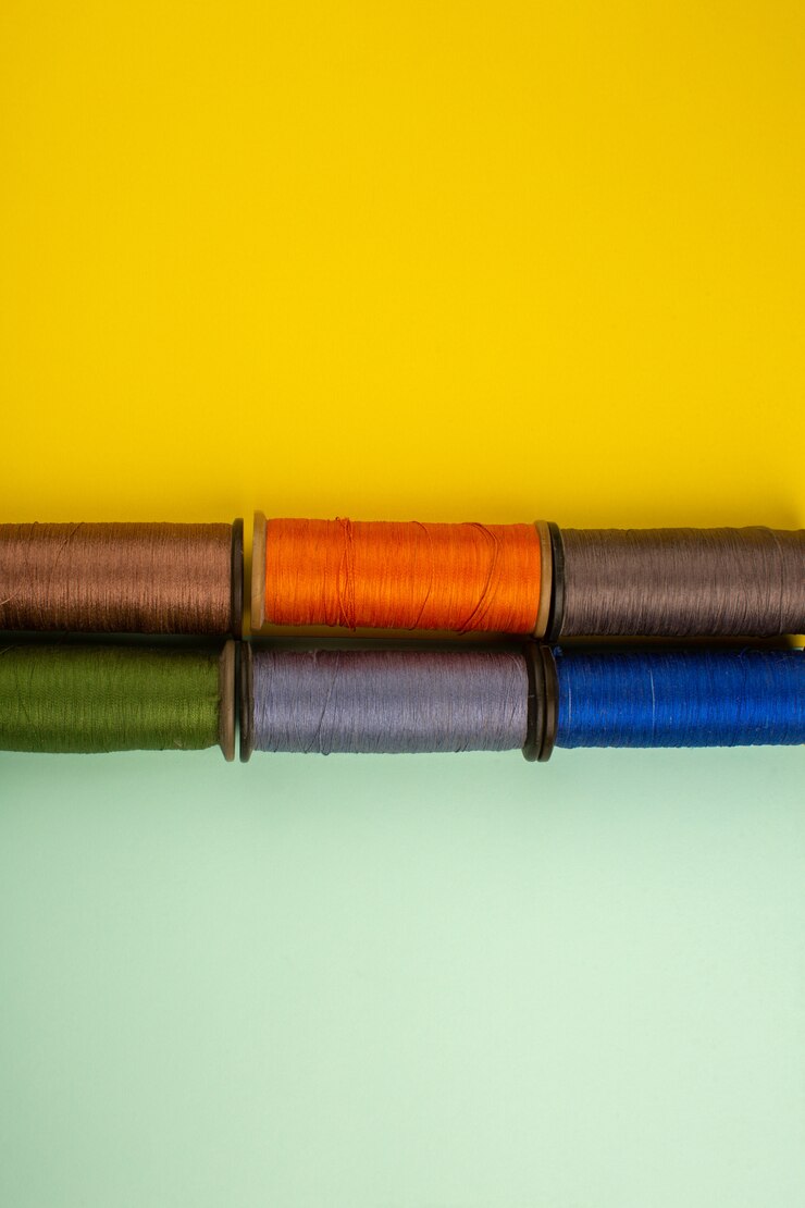 Foto gratuito hilos de coser coloridos en un escritorio de color verde amarillo