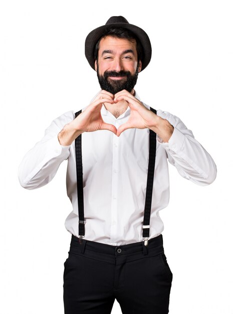 Hipster hombre con barba haciendo un corazón con sus manos