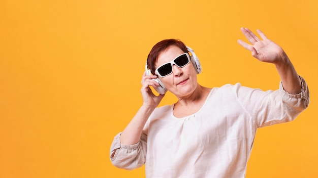 Hipster senior femenino escuchando música