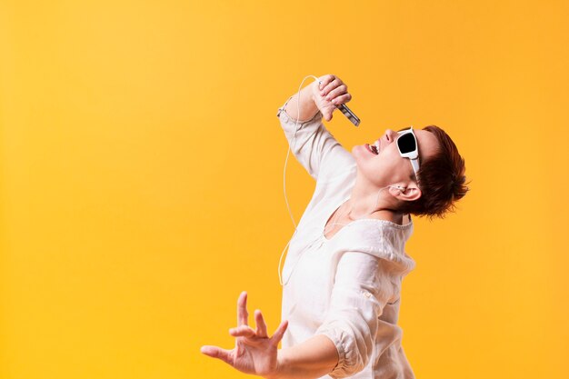 Foto gratuita hipster senior mujer bailando y cantando