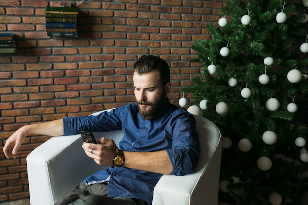 Hipster con smartphone antes de fiesta de año nuevo