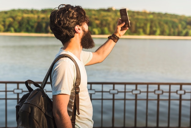 Hipster de vacaciones al lado de lago