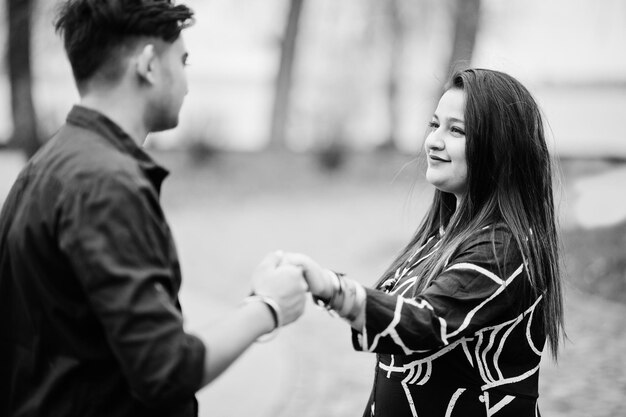 Historia de amor de una pareja india posada al aire libre tomados de la mano juntos