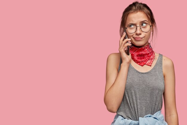 Hmm, ¿por qué no responde? Foto de niña perpleja indignada tiene conversación telefónica