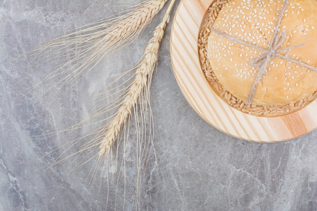 Una hogaza de pan blanco con grano de avena sobre tabla de madera