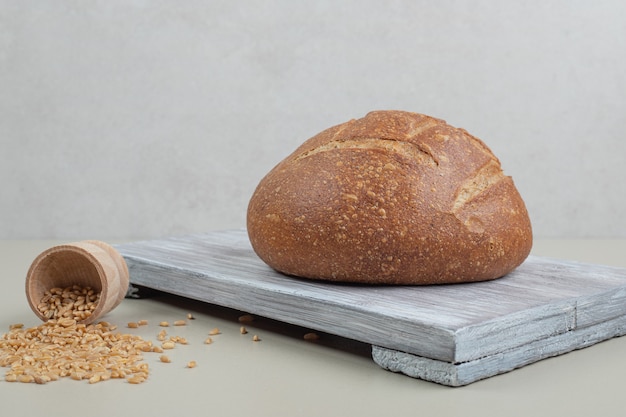 Hogaza de pan fresco con granos de avena sobre fondo blanco. Foto de alta calidad