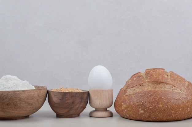 Hogaza de pan con huevo cocido y granos de avena. Foto de alta calidad