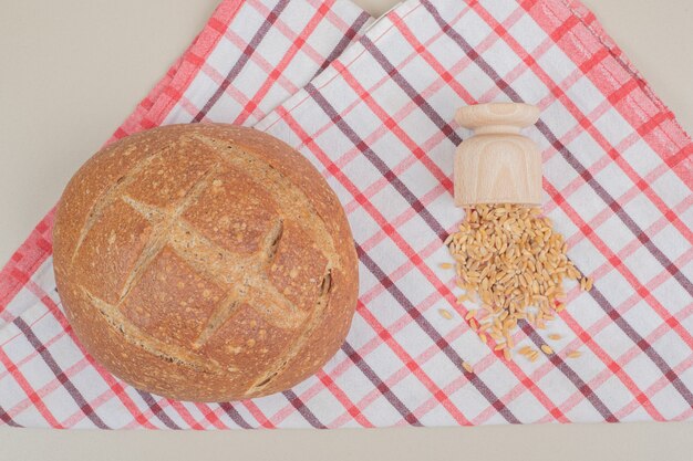 Hogaza de pan redondo con granos de avena sobre mantel