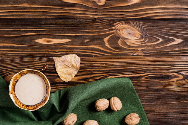 Hoja y bebida cerca de servilleta y nueces