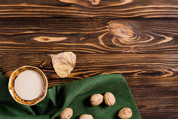 Hoja y bebida cerca de servilleta y nueces