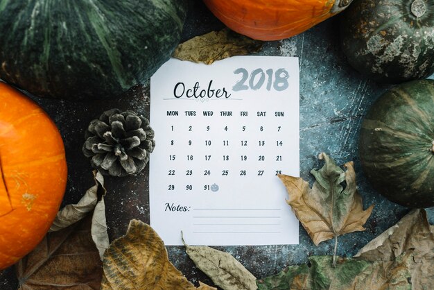 Hoja de calendario con fecha de Halloween en calabazas y hojas