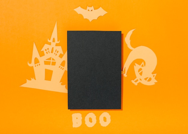 Hoja negra con decoraciones de papel de Halloween e inscripción Boo