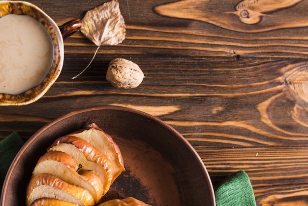 Foto gratuita hoja y nuez cerca de bebida y manzana al horno