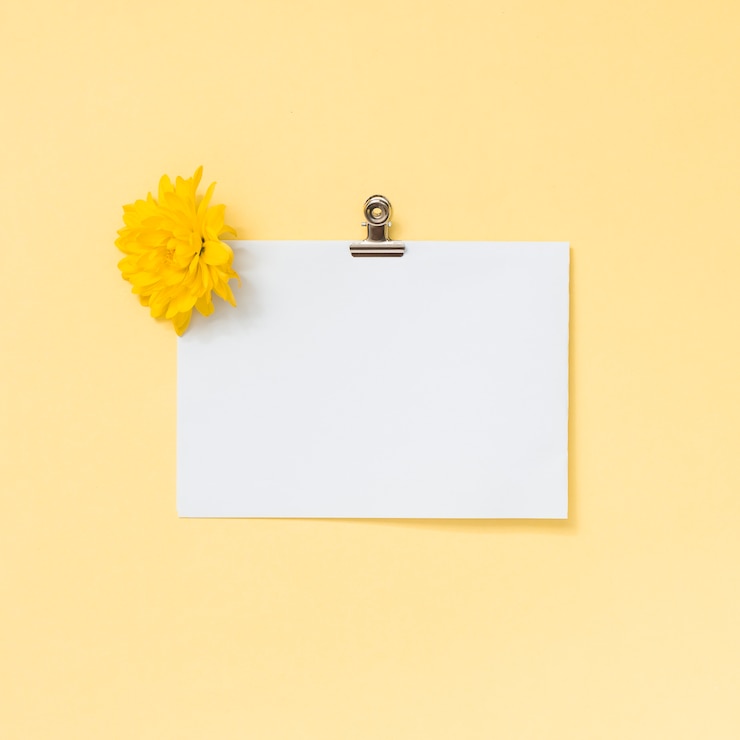 Foto gratuito hoja de papel en blanco con flor amarilla