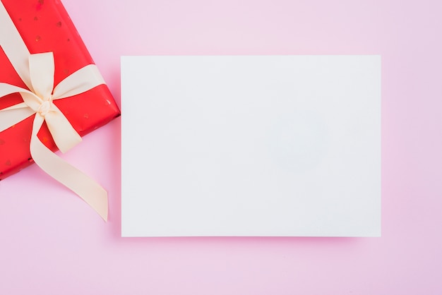 Hoja de papel cerca de la caja de San Valentín en rosa