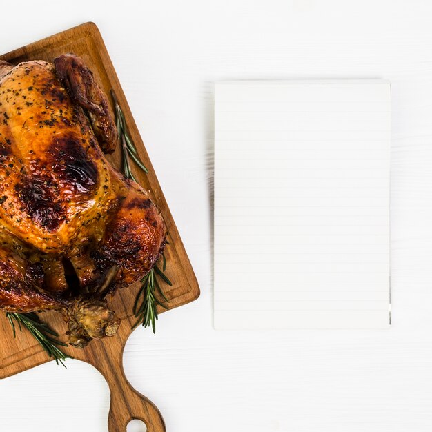 Hoja de papel cerca de pollo delicioso