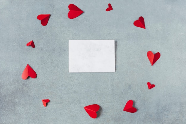 Foto gratuita hoja entre los símbolos de papel rojo del corazón en forma de círculo