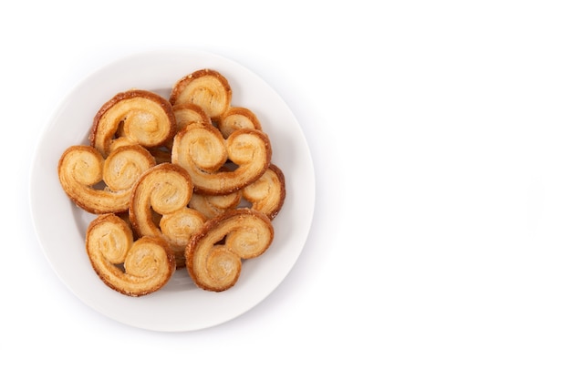 Hojaldre Palmier en placa aislado sobre fondo blanco.