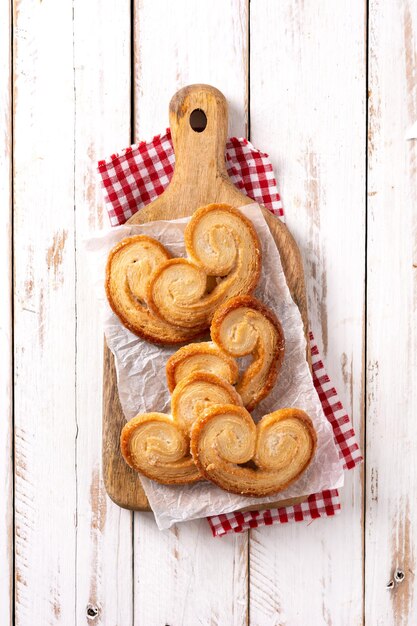 Hojaldre Palmier en placa sobre mesa de madera blanca